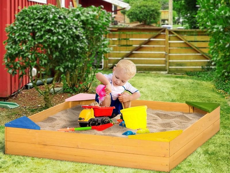 Dítě s hračkami na zahradním pískovišti